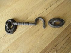 an old metal hook and nut on a wooden table