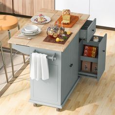 a kitchen island with food and drinks on it in the middle of a wooden floor