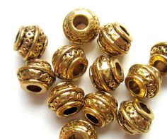 a bunch of gold colored beads on a white surface