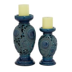 two blue vases with candles in them on a white background and one is holding a candle