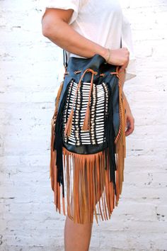 Boho style fringed leather bag black with tan fringes and white bone choker Bone bead choker attached as decoration Fully lined inside with one pocket. strap can be adjusted to several lengths. Material: leather, cow bones 26 cm wide,39 cm long. total long include leather fringes 60 cm Best finishing quality Please note that our products are handmade with some natural materials. For this reason the used materials such as leather and feathers may have slight variations in color. Please do not for Chic Brown Fringe Hobo Bag, Leather Fringe Hobo Bag For Festivals, Chic Brown Hobo Bag With Tassels, Festival Fringe Hobo Shoulder Bag, Black Hobo Bag With Tassels For Everyday Use, Festival Fringe Hobo Tote Bag, Bohemian Brown Bag With Beaded Fringe, Black Tasseled Hobo Bag, Black Bohemian Bag With Fringe