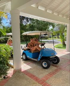 two women riding in a blue golf cart