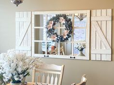 a dining room table and chairs with flowers in vases