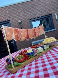 a table topped with lots of different types of food on top of a red and white checkered table cloth