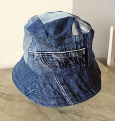 5. Blue jeans bucket hat. For him or her. This hat is made from upcykled blue denim. I sewn it on my lovely vintage sewingmachine. And yes, you can tell this item is handmade and quite unike.  It has a small  zipper pocket and several seams from the fabric, wich use to be trousers. The top of this hat is made from small patches. Inside has a cord in a canal in the lining Inside lining is from light lilac cotton. You can wash in machine, 40 celicius and iron the brim. The brim is sturdy enough to Blue Cotton Wide Brim Hat, Blue Cotton Sun Hat One Size Fits Most, Blue Cotton Bucket Hat For Outdoor, Blue Cotton Sun Hat For Outdoor Use, Blue Cotton Sun Hat For Outdoor, Blue Wide-brim Cotton Sun Hat, Blue Wide Brim Cotton Sun Hat, Blue Cotton Wide Brim Sun Hat, Vintage Denim Hat In Medium Wash