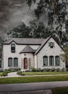 a white house with dark clouds in the background