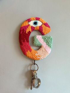 a multicolored keychain hanging on the wall with an eyeball design