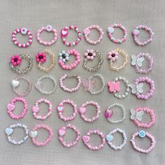 a bunch of bracelets that are laying on a table with flowers and hearts around them