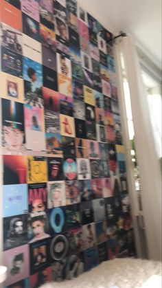 a room with a bed and a wall covered in posters