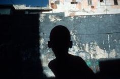 the silhouette of a man standing in front of a building with graffiti on it's walls