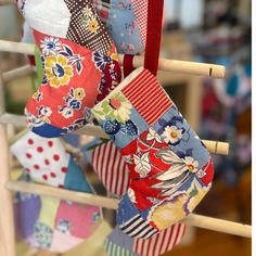 several colorful ties hanging from a clothes line with wooden poles and pegs in the background