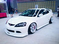 a white car is parked in a showroom