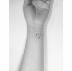 a small heart tattoo on the wrist