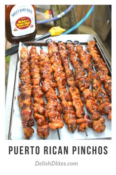 several skewers of chicken on a grill with ketchup