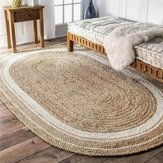 a large round rug in the middle of a room next to a bed and table