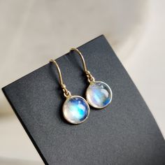 ITEM DESCRIPTION: >> The earrings are made from Solid 14K Yellow Gold. Gemstone used is absolutely natural and ethically sourced. >> Natural Rainbow Moonstone in round shape and cabachon cut with bezel setting is studded on it with utmost precision.  >> This is a minimalist design and is absolutely hassle-free and everyday jewelry.  Gem: Rainbow Moonstone Gem size: 8 mm round Gem weight: 4.22 carats Gold purity: 14K (58.33% approx.) Gold weight: 0.57 grams  Gross weight: 1.41 grams The Gold purity is guaranteed and it comes with authentic 14K gold hallmark. Since these Earrings are handmade, they are Nickel/Lead FREE.  CUSTOMIZATION: --> You can choose your own gemstone. --> Kindly drop a message for more options. CUSTOMER SUPPORT: We are available 24/7 to respond to all your queries!  PAC Moonstone Round Yellow Gold Earrings, Round Moonstone Yellow Gold Earrings, Moonstone Yellow Gold Round Earrings, Yellow Gold Round Moonstone Earrings, Round Gold Moonstone Earrings, Gift Dangle Earrings With Bezel Setting, White Bezel Setting Earrings For Gift, Handmade Jewelry Box, Bezel Earrings