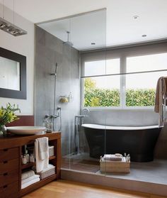 a bathroom with a tub, sink and large window in the middle of it's wall