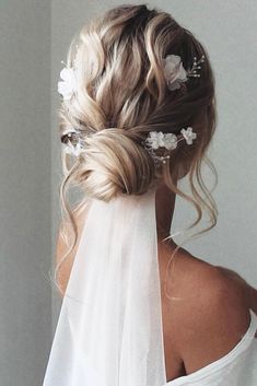 the back of a woman's head wearing a veil and flowers in her hair