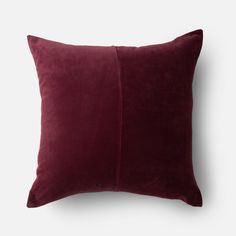 a dark red velvet pillow on a white background