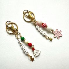 two key chains with charms attached to them on a white surface, one has an ornament and the other has christmas decorations