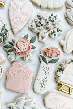 cookies decorated with flowers and leaves are on a table top, surrounded by other cookie decorations