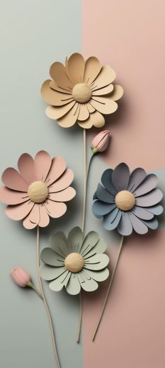 three paper flowers on a pink and blue background