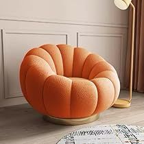 an orange chair sitting on top of a wooden floor next to a lamp and rug