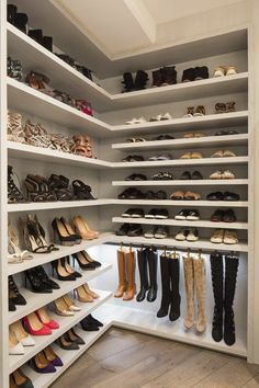 a walk in closet filled with lots of shoes