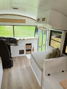 the interior of an rv with wood flooring and white furniture, including a bed