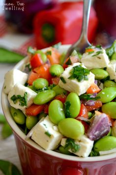 a red bowl filled with vegetables and tofu