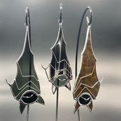 three metal sculptures with different designs on them