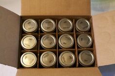 a box filled with lots of silver colored metal cups sitting on top of a table