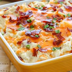 a casserole dish with bacon, cheese and green onions