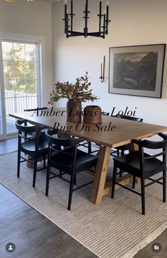 a dining room table with chairs and a vase filled with flowers on top of it