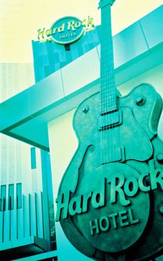 the hard rock hotel sign has an electric guitar hanging from it's back end