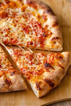 a sliced pizza sitting on top of a wooden cutting board