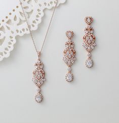 This elegant rose gold set includes a necklace and long earrings, perfect for any special occasion. Made with sparkling cubic zirconia, this bridal jewelry set will add a touch of sophistication to any outfit. Elevate your style with this stunning set. Earrings measure: 2-3/8" x 5/8" Necklace measures 16 inches and extends to 18 inches Pendant measures 2.25" x 5/8" Matching bracelets: https://www.etsy.com/listing/1176583910/rose-gold-bridal-bracelet-bridal-jewelry?click_key=2e79066e4a2baedd03d8b6887dc369b1ab0c44ee%3A1176583910&click_sum=cb922bf6&ref=shop_home_active_7&pro=1&frs=1&sts=1 https://www.etsy.com/listing/456883848/rose-gold-bridal-bracelet-crystal?click_key=7a64e423401062f59ef78bdd51b062fb2d1d71af%3A456883848&click_sum=a4525089&ref=shop_home_active_26&pro=1&frs=1&sts=1 https://ww Wedding Statement Earrings, Gold Wedding Necklace, Necklace For Wedding, Earrings For Bride, Gold Necklace Wedding, Wedding Necklace Set, Bracelet Rose Gold, Bridal Jewelry Set, Rose Gold Bridal