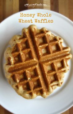 a waffle on a white plate with the words honey whole wheat waffles