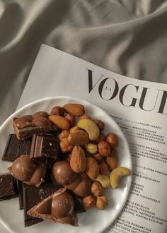 nuts and chocolate on a white plate next to a paper that says voggie