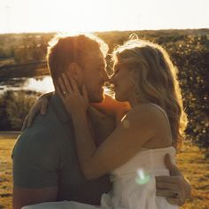 a man and woman embracing each other in front of the sun on a sunny day