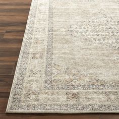 an area rug with wood flooring and wooden floors in the background, including a large beige