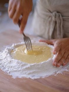 a person is kneading butter on top of flour with a knife and fork