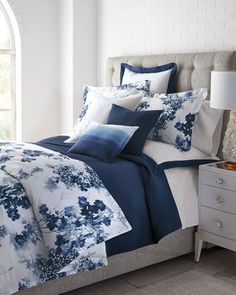 a bed with blue and white flowers on it