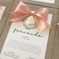 a pink ribbon tied around a ring on top of a piece of paper with the word peranada written in spanish