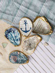 four decorative seashells with an anchor on them