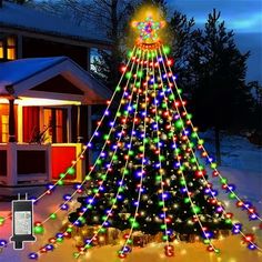 a lighted christmas tree in front of a house