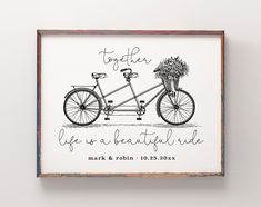 a black and white drawing of a bicycle with flowers on the handlebars is mounted in a wooden frame