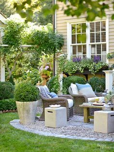 an outdoor living area with chairs, tables and potted plants