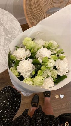 a person holding a bouquet of white flowers