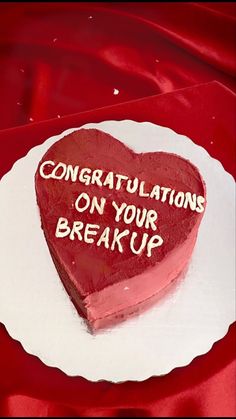 a heart shaped cake with congratulationss on your breakup written on the top and bottom